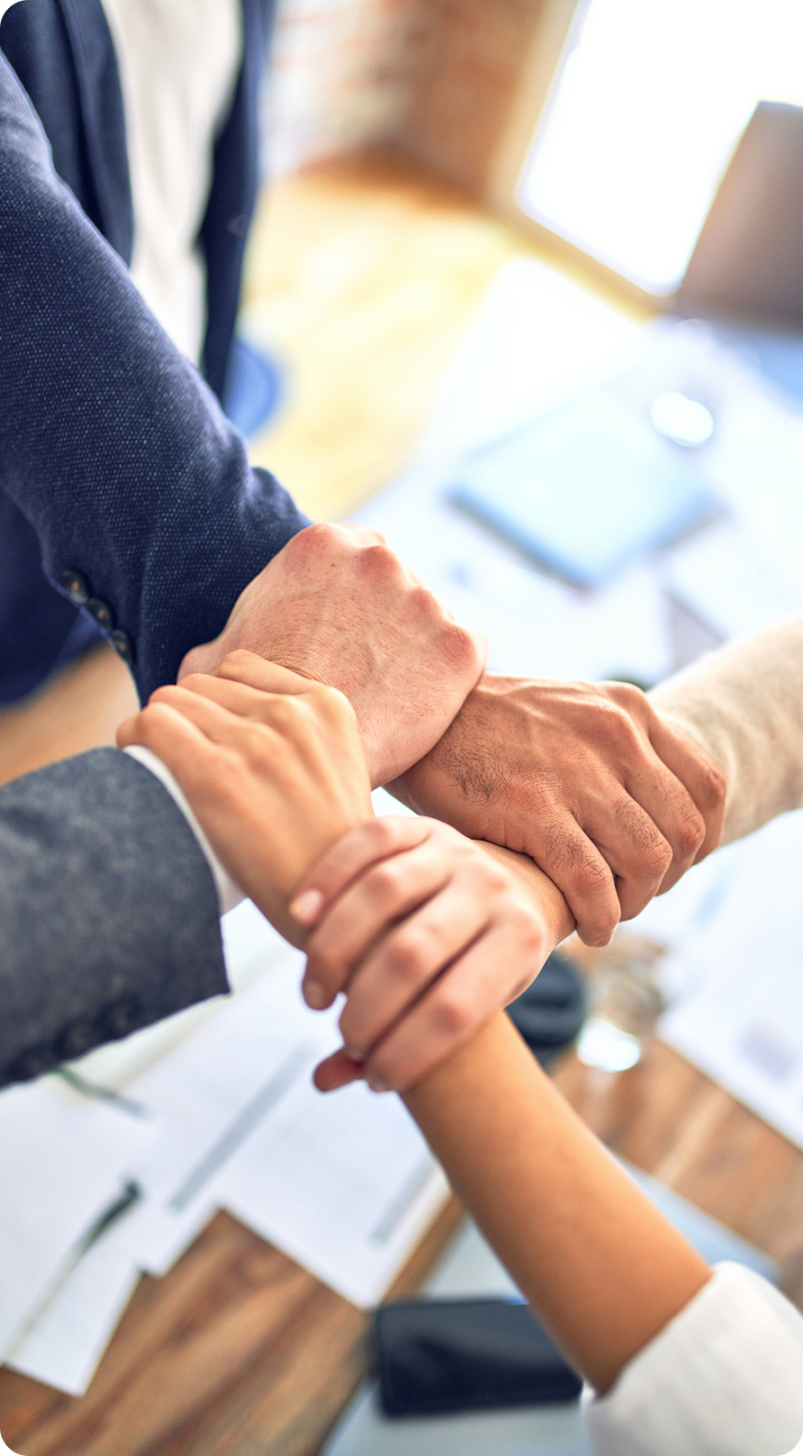 Team members joining hands together in a show of collaboration